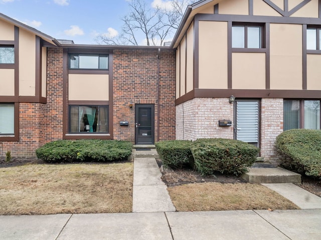 view of front of home featuring stucco siding and brick siding