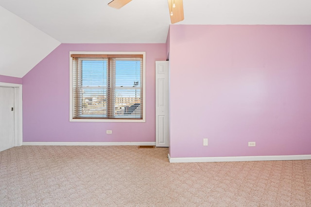 unfurnished bedroom featuring ceiling fan, vaulted ceiling, and light carpet