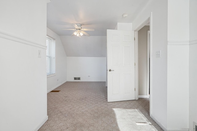 additional living space featuring ceiling fan, vaulted ceiling, and light carpet