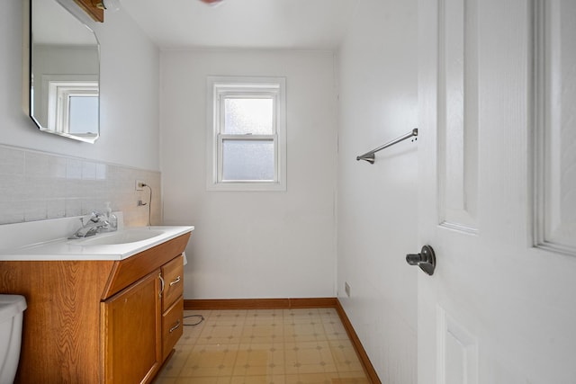 bathroom with vanity, decorative backsplash, and toilet