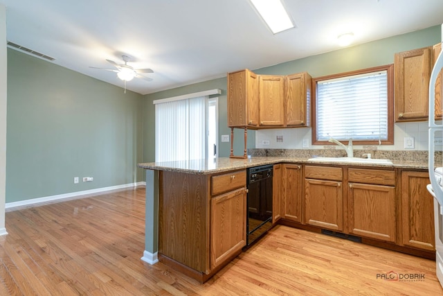 kitchen with sink, light wood-type flooring, dishwasher, kitchen peninsula, and light stone countertops