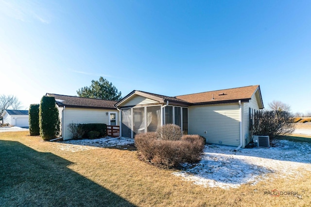 view of front of home featuring cooling unit, a front yard, and a sunroom