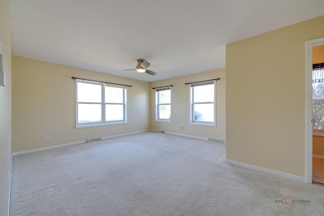 spare room featuring light carpet and ceiling fan