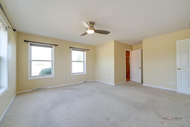 spare room featuring light colored carpet and ceiling fan