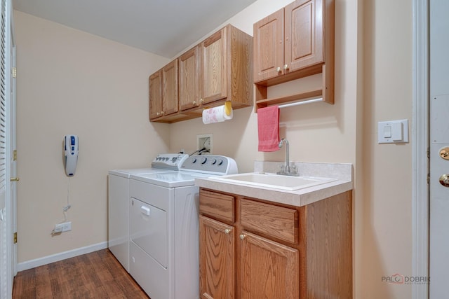 laundry room featuring cabinets, dark hardwood / wood-style flooring, sink, and washer and dryer