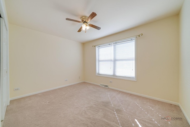 carpeted spare room featuring ceiling fan