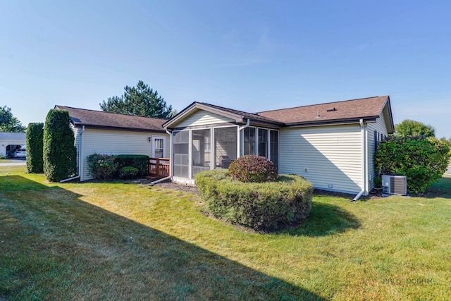 rear view of property with cooling unit, a lawn, and a sunroom