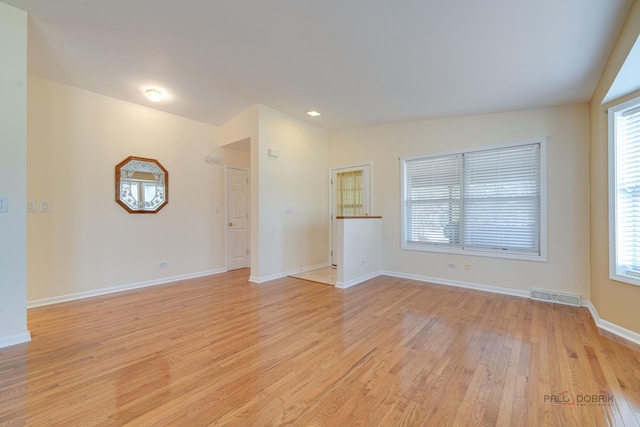 unfurnished living room featuring vaulted ceiling, light hardwood / wood-style floors, and a healthy amount of sunlight