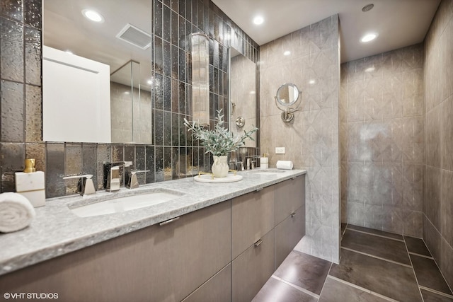 bathroom with tile walls, vanity, and tile patterned flooring