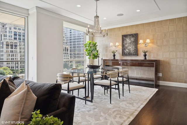 dining space with ornamental molding, hardwood / wood-style floors, and a chandelier