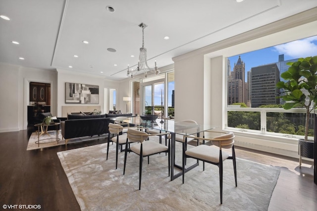 dining area featuring crown molding, light wood-type flooring, and an inviting chandelier