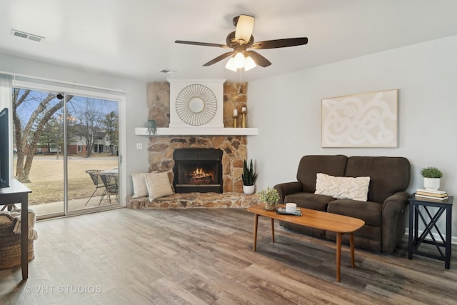 living room with ceiling fan, a fireplace, and hardwood / wood-style floors