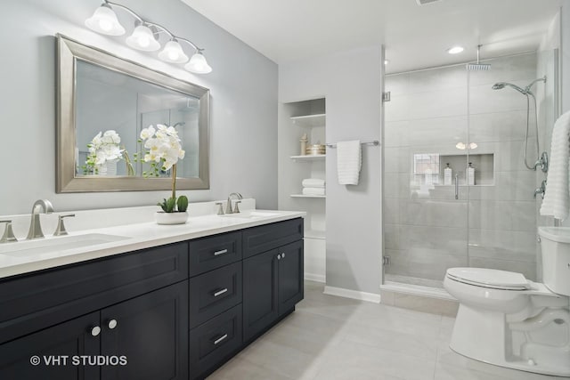 bathroom featuring tile patterned floors, vanity, toilet, and a shower with shower door