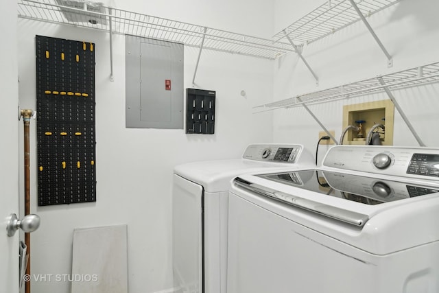 laundry room with electric panel and washing machine and clothes dryer