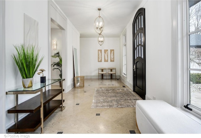 foyer entrance with a notable chandelier and plenty of natural light