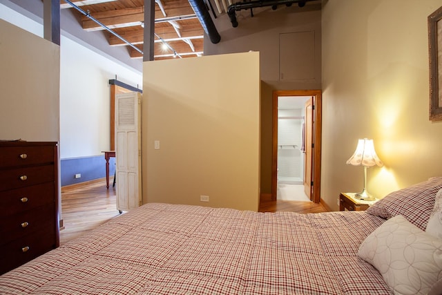 bedroom with beamed ceiling, light wood-type flooring, and wooden ceiling