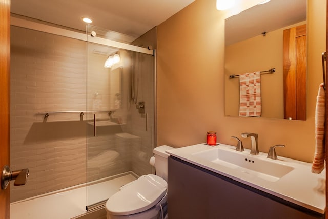 bathroom featuring vanity, toilet, and a shower with door