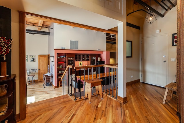 interior space featuring a towering ceiling and hardwood / wood-style flooring