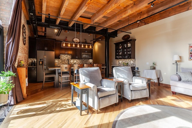 sitting room featuring beamed ceiling, track lighting, light hardwood / wood-style floors, and wooden ceiling