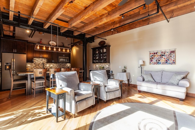 living room featuring beam ceiling, wooden ceiling, rail lighting, and light wood-type flooring