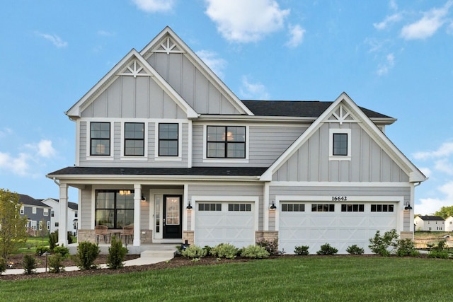 view of front of property with a garage, a front lawn, and a porch