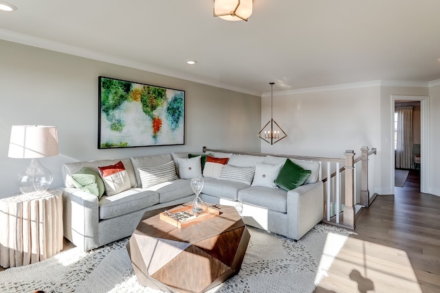 living room featuring a notable chandelier, hardwood / wood-style flooring, and ornamental molding