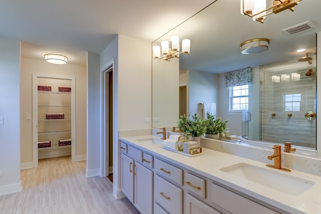 bathroom with walk in shower, vanity, a chandelier, and hardwood / wood-style flooring