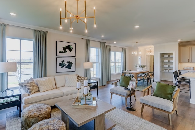 living room featuring ornamental molding, a chandelier, and light hardwood / wood-style floors