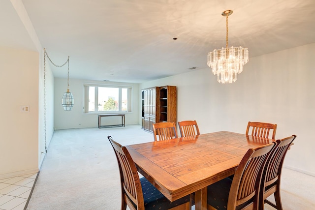 dining space featuring light colored carpet and a chandelier