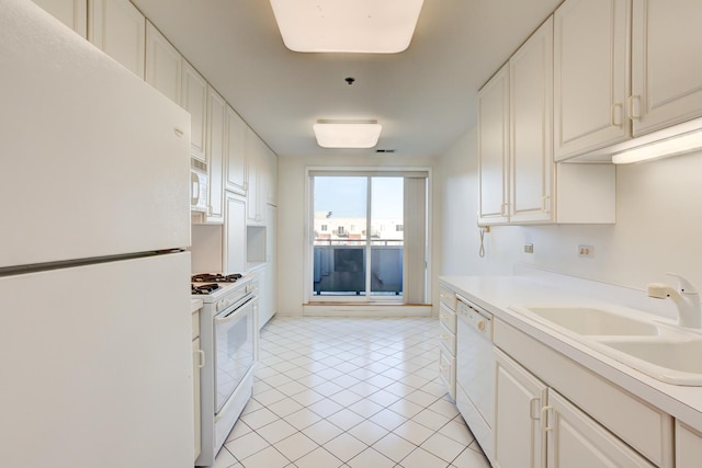 kitchen featuring light tile patterned floors, light countertops, white cabinetry, a sink, and white appliances