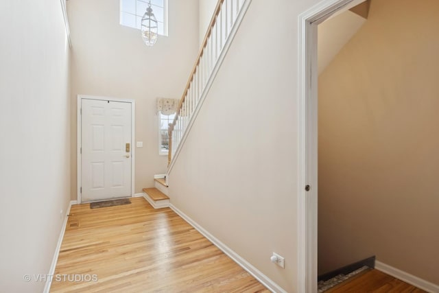 entrance foyer featuring hardwood / wood-style flooring and a towering ceiling