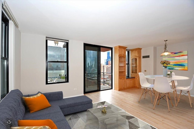 living room with floor to ceiling windows and light wood-type flooring