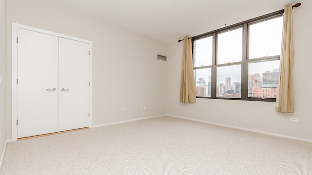 unfurnished bedroom with multiple windows, a closet, and carpet flooring