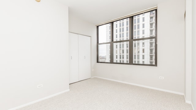 unfurnished bedroom featuring light carpet and a closet