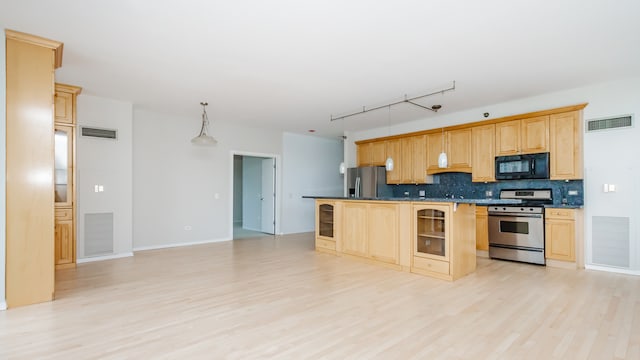 kitchen with appliances with stainless steel finishes, backsplash, light brown cabinets, decorative light fixtures, and light wood-type flooring