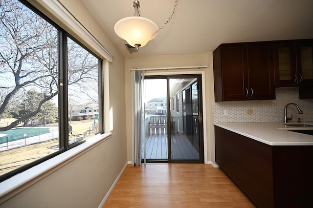 kitchen featuring a wealth of natural light, sink, dark brown cabinets, and backsplash