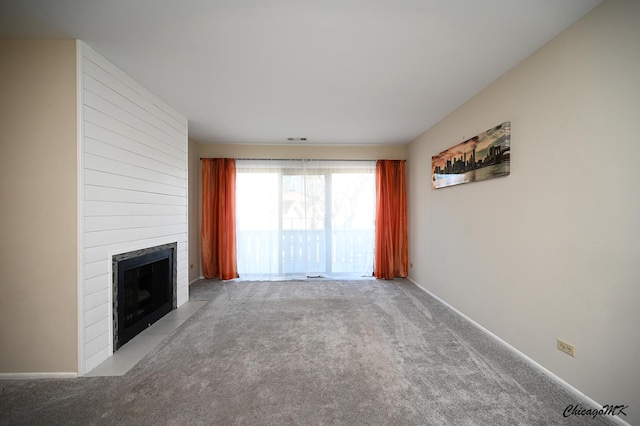 unfurnished living room with a fireplace and carpet flooring