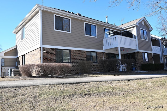 back of property featuring a balcony and central AC