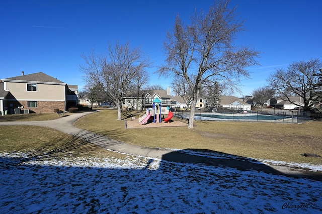 snow covered playground featuring a lawn