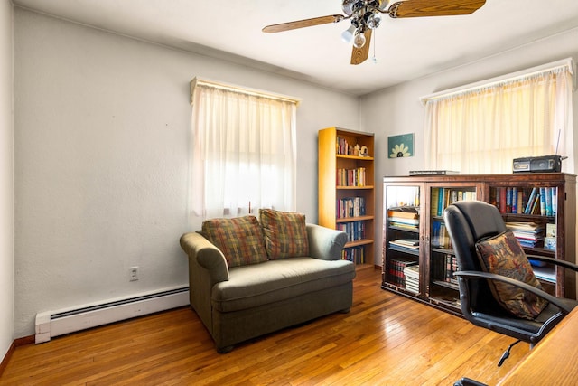 office area featuring hardwood / wood-style flooring, ceiling fan, and baseboard heating