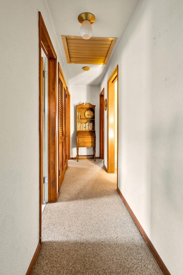 hallway featuring light colored carpet