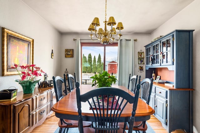 dining space with an inviting chandelier and light hardwood / wood-style flooring