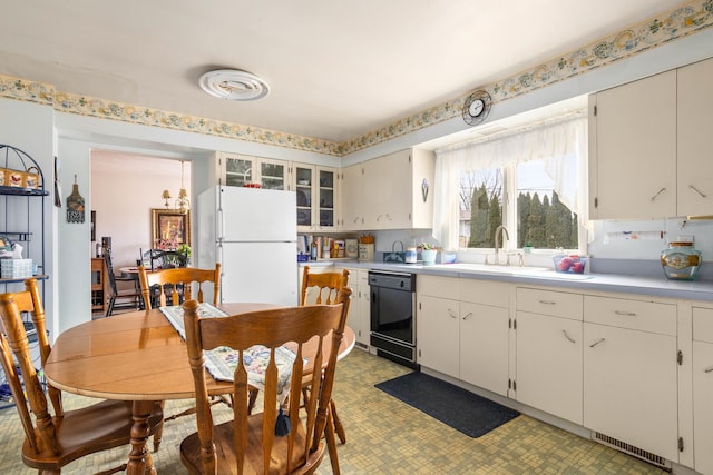 kitchen with white refrigerator, black dishwasher, and white cabinets