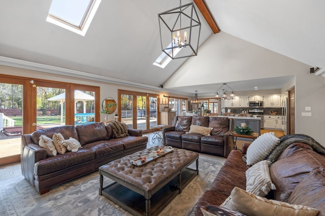 living room with beam ceiling, french doors, a chandelier, and a skylight