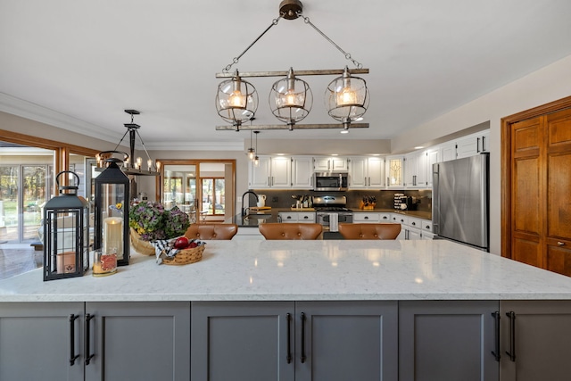 kitchen featuring gray cabinetry, pendant lighting, stainless steel appliances, and white cabinets