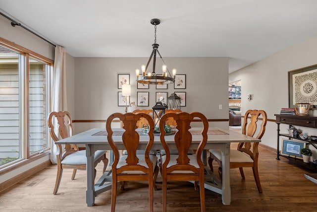 dining space featuring hardwood / wood-style flooring and a chandelier