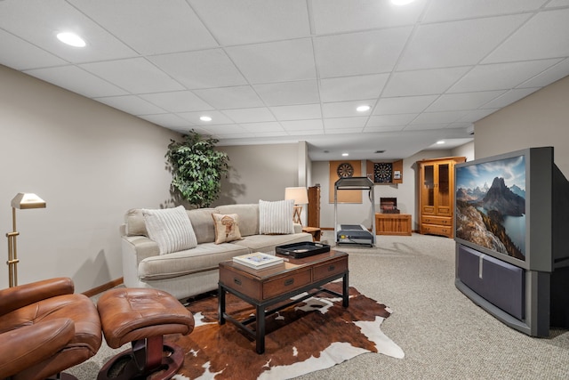 living room featuring carpet and a paneled ceiling