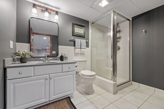 bathroom featuring vanity, toilet, an enclosed shower, and tile patterned flooring