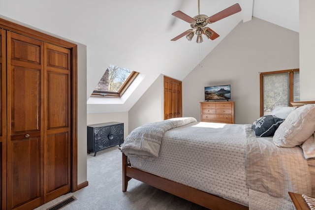 bedroom featuring light carpet, vaulted ceiling with skylight, and ceiling fan