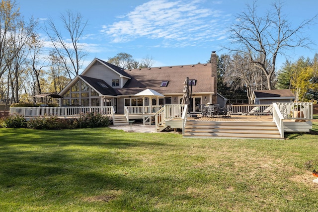 rear view of property with a lawn and a deck